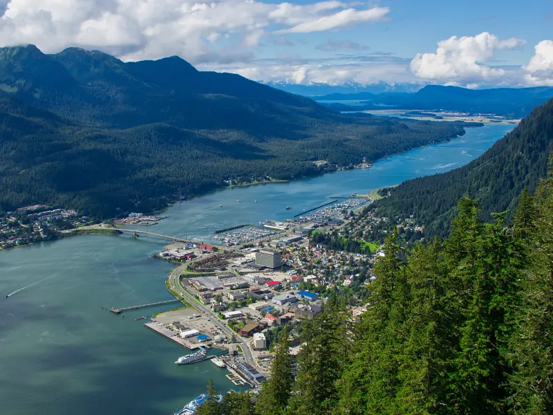 Aerial view of downtown Juneau, Alaska, with the waterfront, harbor, and surrounding mountains